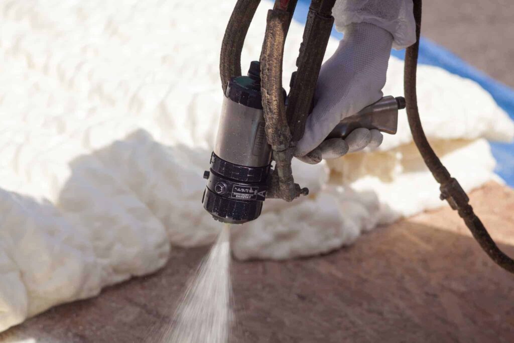 A Bell Brothers technician, wearing gloves, expertly applies spray foam insulation to ensure maximum energy efficiency. With our No Surprise Guarantee, you can count on honest, upfront pricing and background-checked professionals you can trust. Proudly serving Northern California communities with a strong reputation for reliable service—no surprises, just comfort.