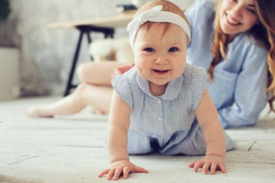 A happy baby in a headband and striped dress crawls across the floor while an adult woman smiles warmly in the background, reflecting the peace of mind families enjoy thanks to Bell Brothers’ trusted service. Our No Surprise Guarantee, thorough background checks for all technicians, and clear upfront pricing have made us a top choice for homes throughout Northern California communities.