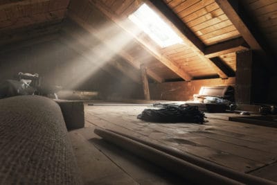 A dusty attic with wooden floors and beams is softly illuminated by sunlight streaming through a small skylight, with various items scattered about. Trust Bell Brothers’ background-checked technicians to handle your attic needs with care, backed by our No Surprise Guarantee and upfront pricing—a reputation for reliable service that communities across Northern California count on.