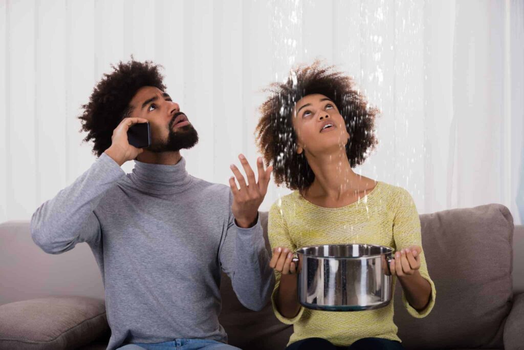 A worried couple sits on their couch as water leaks from the ceiling—one person calls for help while the other catches water in a pot. With Bell Brothers, you can count on a trusted team of background-checked technicians, clear upfront pricing, and our No Surprise Guarantee. We're proud to serve Northern California communities with reliable service you can depend on.