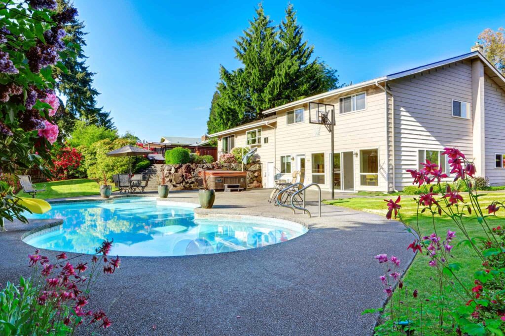 A beautifully landscaped backyard featuring a round swimming pool and comfortable lounge chairs beside a spacious two-story beige home with large windows. Bell Brothers is proud to serve Northern California communities, offering our trusted No Surprise Guarantee, fully background-checked technicians, and honest upfront pricing for your peace of mind.