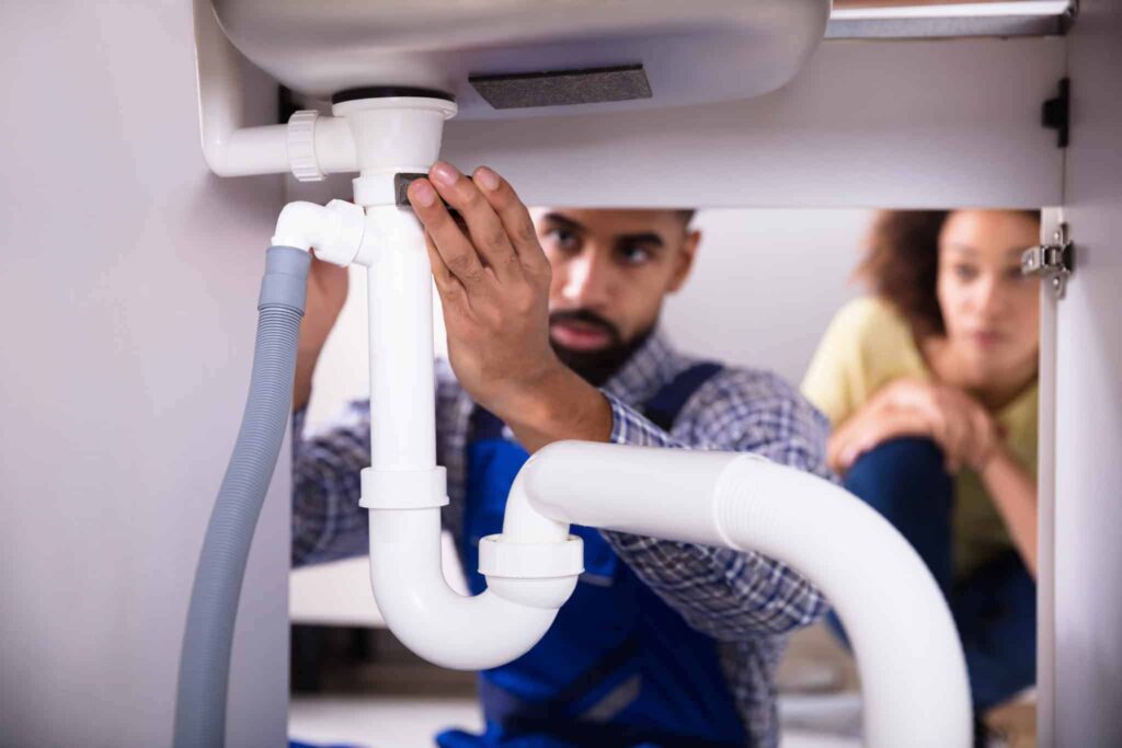 A trusted Bell Brothers plumber, backed by our No Surprise Guarantee, repairs pipes beneath a sink as a customer looks on. Our background-checked technicians provide upfront pricing and deliver the dependable service Northern California communities rely on.