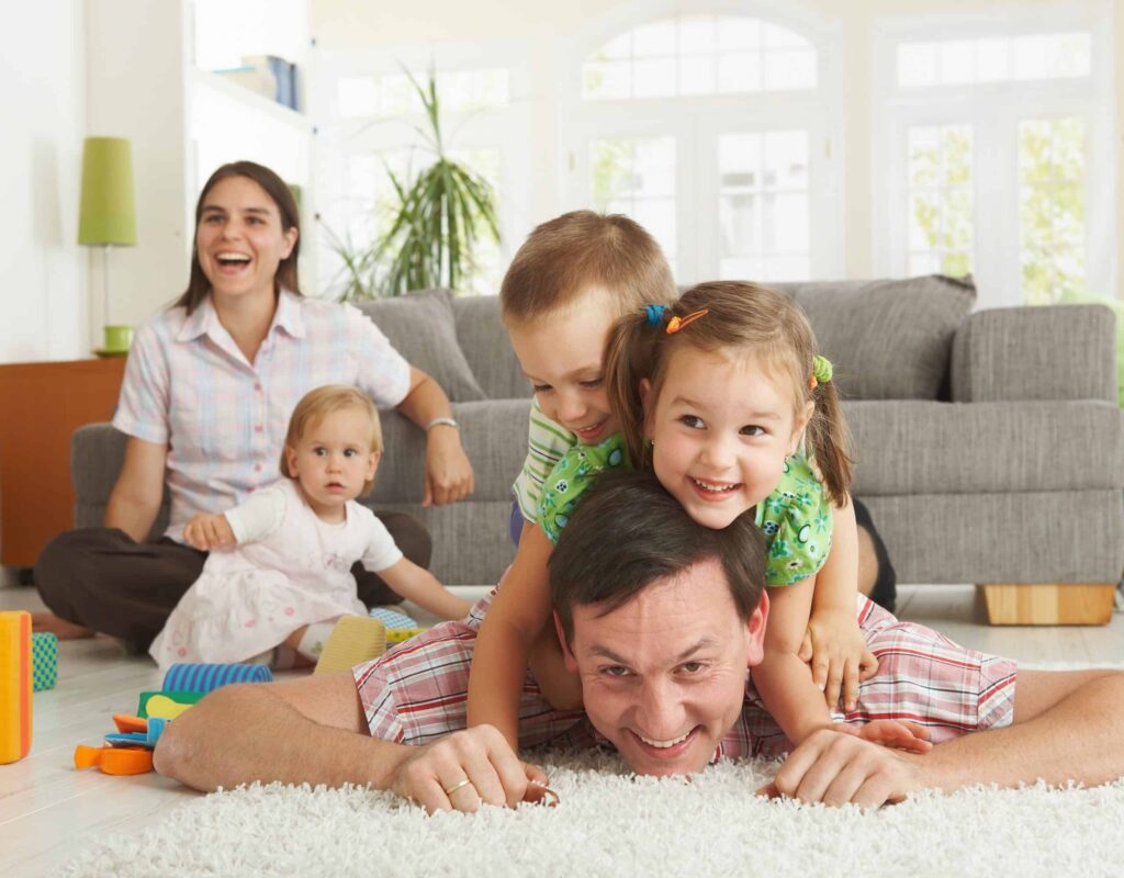 A happy family enjoys quality time together in their bright living room, confident in the comfort and safety provided by Bell Brothers. With our No Surprise Guarantee, background-checked technicians, and upfront pricing, families across Northern California trust us to keep their homes running smoothly—no surprises, just reliable service from a team with community roots.
