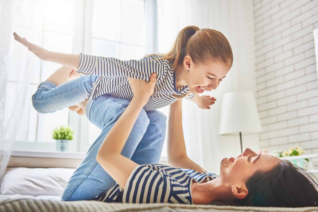 A parent and child, both happily smiling in matching striped shirts, enjoy playful time together in a sunlit room. Bell Brothers is dedicated to creating this comfort and peace of mind for families throughout Northern California, with our trusted No Surprise Guarantee, background-checked technicians, upfront pricing, and a strong reputation built on years of exceptional service in your community.