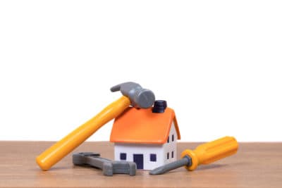 A small model house sits on a wooden surface, topped with a hammer, screwdriver, and wrench—symbolizing the expert home services Bell Brothers proudly provides. With our No Surprise Guarantee, thoroughly background-checked technicians, and honest upfront pricing, it’s easy to see why Northern California communities trust Bell Brothers for reliable heating, cooling, and plumbing care.