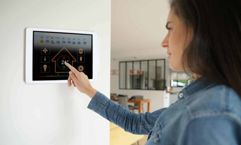 A woman adjusts the temperature on a wall-mounted smart home touchscreen, enjoying complete control and comfort in her modern living space. With Bell Brothers’ trusted service—including our No Surprise Guarantee, thoroughly background-checked technicians, transparent upfront pricing, and longstanding reputation throughout Northern California communities—homeowners can feel confident that every visit brings reliable results and peace of mind.