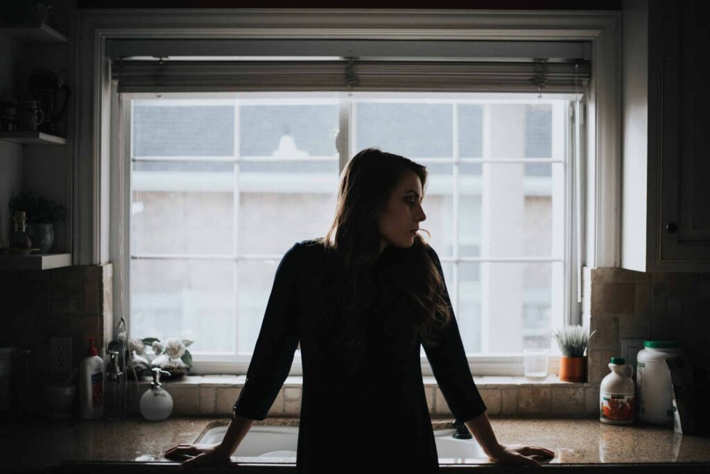 A woman stands at her kitchen sink, bathed in natural daylight as she looks out the window with confidence and peace of mind. She feels reassured knowing Bell Brothers’ trusted, background-checked technicians provide reliable service backed by our No Surprise Guarantee, upfront pricing, and a strong reputation throughout Northern California communities.
