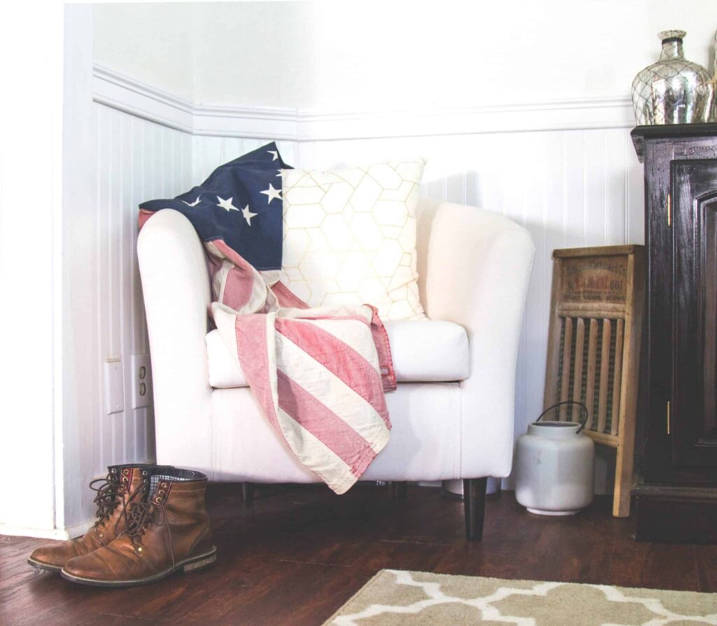 A cozy white armchair, adorned with an American flag and comfortable pillows, sits beside a pair of brown boots and a stylish black cabinet on a warm wooden floor. Bell Brothers’ No Surprise Guarantee and trusted, background-checked technicians provide Northern California communities with honest service and upfront pricing—earning a reputation for straightforward solutions you can rely on.