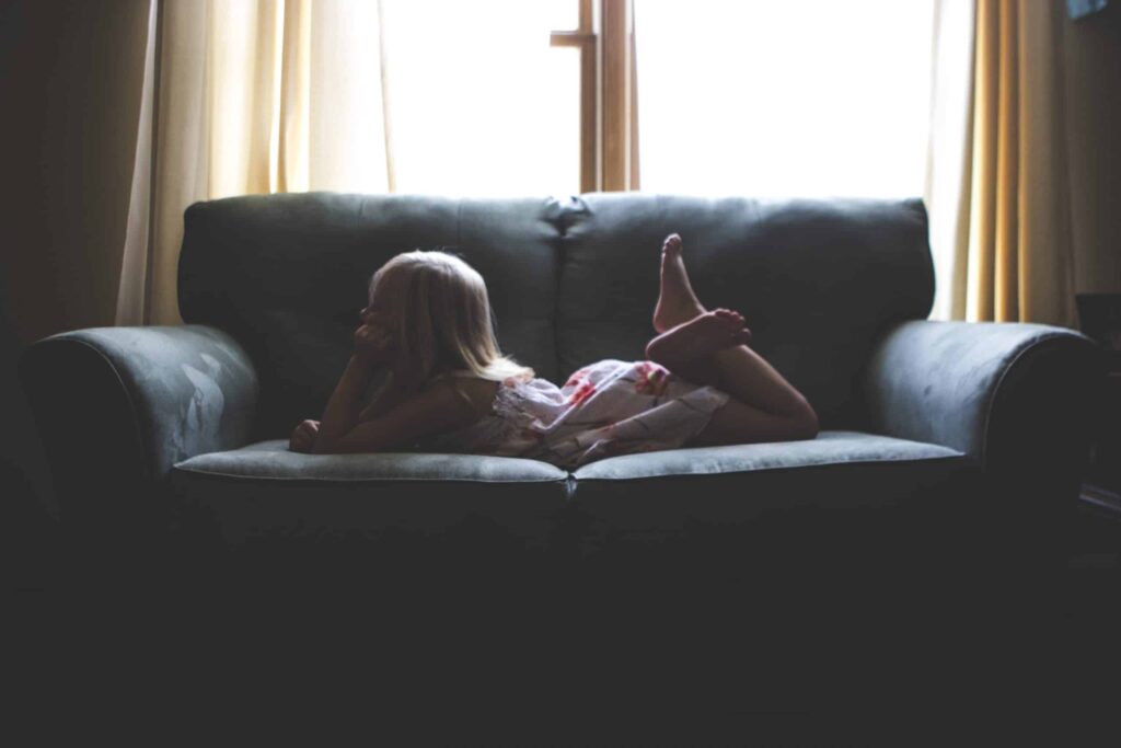 A young child relaxes comfortably on a dark sofa in front of a sunlit window, feeling safe and secure—just like our customers across Northern California. At Bell Brothers, our No Surprise Guarantee means you can always count on upfront pricing and trusted service from thoroughly background-checked technicians. That’s why families throughout the region rely on us for honest, professional care every time.