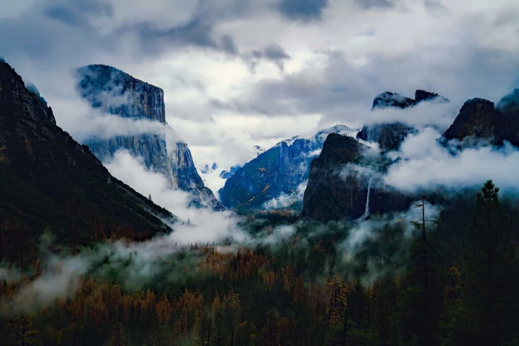 A peaceful, misty forest valley framed by tall, rocky mountains and gentle waterfalls under a cloudy sky—much like how Bell Brothers brings clarity and peace of mind to communities all across Northern California. Count on our trusted service backed by the No Surprise Guarantee, expert background-checked technicians, and honest upfront pricing with every visit.