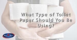 Image: a man holding many rolls of toilet paper, cover image for What Type of Toilet Paper Should You Be Using?