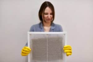 woman holding a dirty air filter